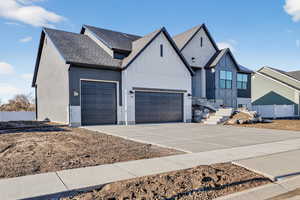 Modern inspired farmhouse with driveway, a shingled roof, board and batten siding, and an attached garage