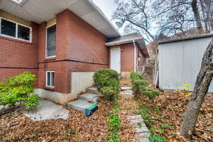 View of home's exterior with brick siding and a storage shed