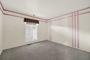 Unfurnished room featuring carpet floors and crown molding