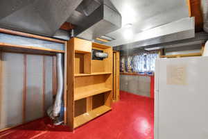 Unfinished below grade area with freestanding refrigerator