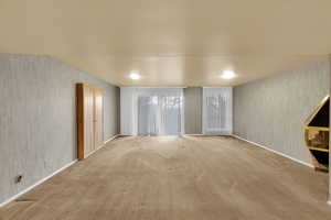 Carpeted spare room with wallpapered walls