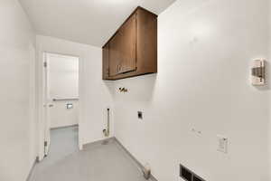 Laundry area with gas dryer hookup, cabinet space, hookup for an electric dryer, and washer hookup