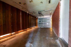Garage with a garage door opener and wood walls