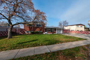 Tri-level home with brick siding, driveway, and a garage