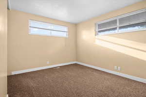 Carpeted empty room featuring baseboards