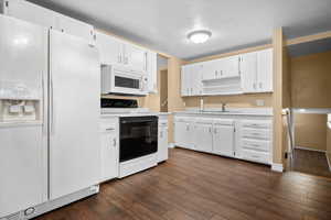 Kitchen featuring white appliances, light countertops, open shelves, and white cabinets