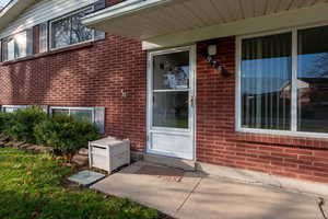View of exterior entry featuring brick siding