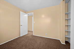 Carpeted spare room with baseboards