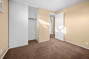 Unfurnished bedroom featuring carpet and a closet