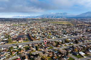 Aerial view of property and surrounding area with nearby suburban area and mountains