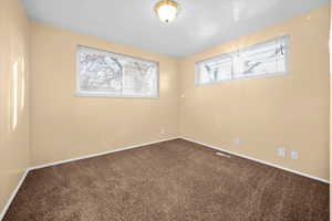 Empty room with carpet flooring and baseboards