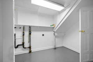 Laundry room featuring electric dryer hookup and finished concrete floors