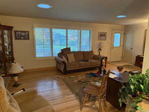 Living area with plenty of natural light, light wood finished floors, and recessed lighting