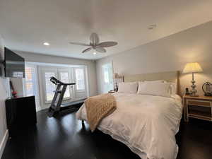 Primary bedroom with with dark wood finished floors, and French Doors leading to private patio area.