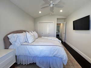 Guest bedroom with vaulted ceiling, ceiling fan, dark wood finished floors.