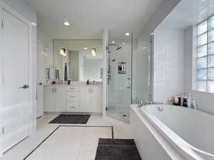 Primary bathroom with double vanity and separate walk-in shower and tub