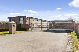 View of asphalt street featuring a gate and a gated entry