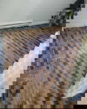 Detailed view of wood finished floors and a baseboard radiator