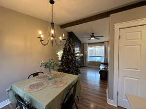 Dining area with ceiling fan, dark wood-style flooring, and a chandelier