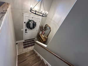 Entrance foyer featuring dark tile patterned floors, stairs, and a chandelier