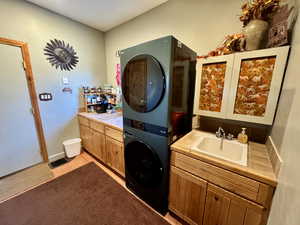 Bathroom featuring stacked washing machine and dryer and vanity