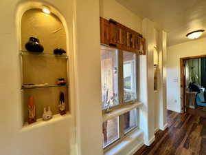 Hall with baseboards and dark wood finished floors