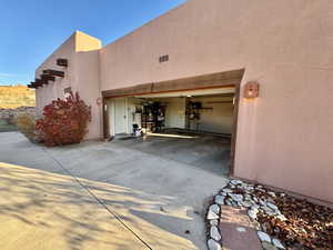 View of home's exterior featuring a garage, concrete driveway, and stucco siding