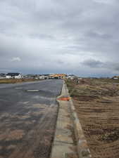 View to the east of asphalt street featuring curbs and a residential view