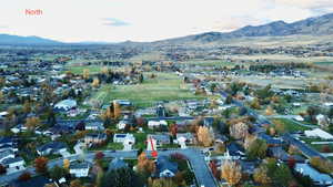 Aerial overview of property's location featuring a mountainous background and nearby suburban area