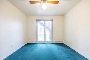 Spare room featuring carpet floors, a ceiling fan, a baseboard heating unit, and baseboard heating