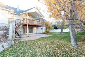 Back of house featuring a patio, a wooden deck, and stairs