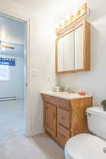 Bathroom with vanity, light carpet, a baseboard heating unit, ceiling fan, and a textured ceiling