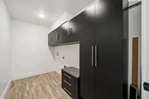 Spacious laundry room with modern cabinetry, abundant storage, and dedicated space for both washer and dryer.