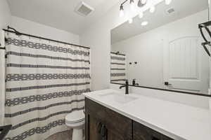 Full bathroom with modern vanity, updated fixtures, and a tub/shower combo with patterned curtain.