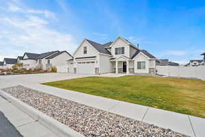 Corner angle of the home showing the manicured lawn, stone accents, and large windows that bring in plenty of natural light.