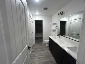 Beautifully updated bathroom featuring a double-sink vanity, modern fixtures, open shelving, and plenty of counter space.