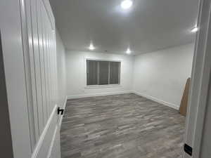 Spacious lower-level primary bedroom with recessed lighting, updated flooring, and a large window for natural light.