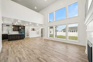Stunning open-concept living area with soaring ceilings, massive windows, and beautiful flooring. Natural light fills the space and flows seamlessly into the modern kitchen.