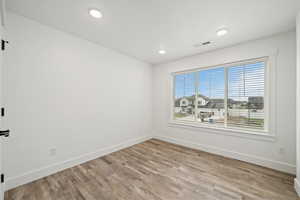 Bright upstairs bedroom with a large window and clean, modern finishes.