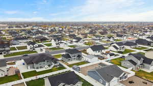 Wide aerial shot highlighting the surrounding community, mountain backdrop, and spacious lot layout.