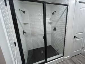 Gorgeous oversized walk-in shower with subway tile surround, dual showerheads, and black-framed glass doors.