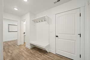 Bright mudroom with built-in bench and hooks. The perfect spot to keep backpacks, coats, and shoes organized.