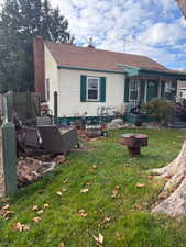 Rear view of house featuring a chimney and a shingled roof