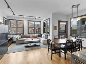 Dining area featuring track lighting, light wood finished floors, and healthy amount of natural light