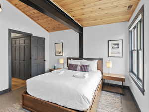 Bedroom with wood ceiling, carpet floors, and a closet