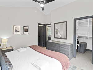 Bedroom with lofted ceiling, ceiling fan, and carpet