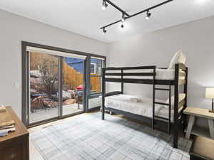 Bedroom featuring rail lighting, access to exterior, and light wood-style floors