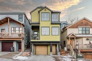 View of front of house with stairway, driveway, and an attached garage