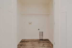 Washroom with light wood-style flooring, washer hookup, and hookup for an electric dryer