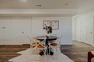 Dining room with dark wood-type flooring and baseboards